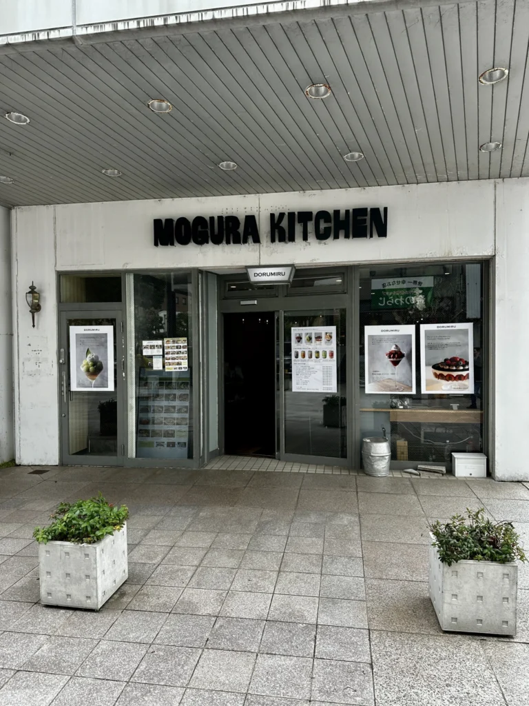 MOGURA KITCHEN竪町店の外観、白い壁と黒文字の看板
