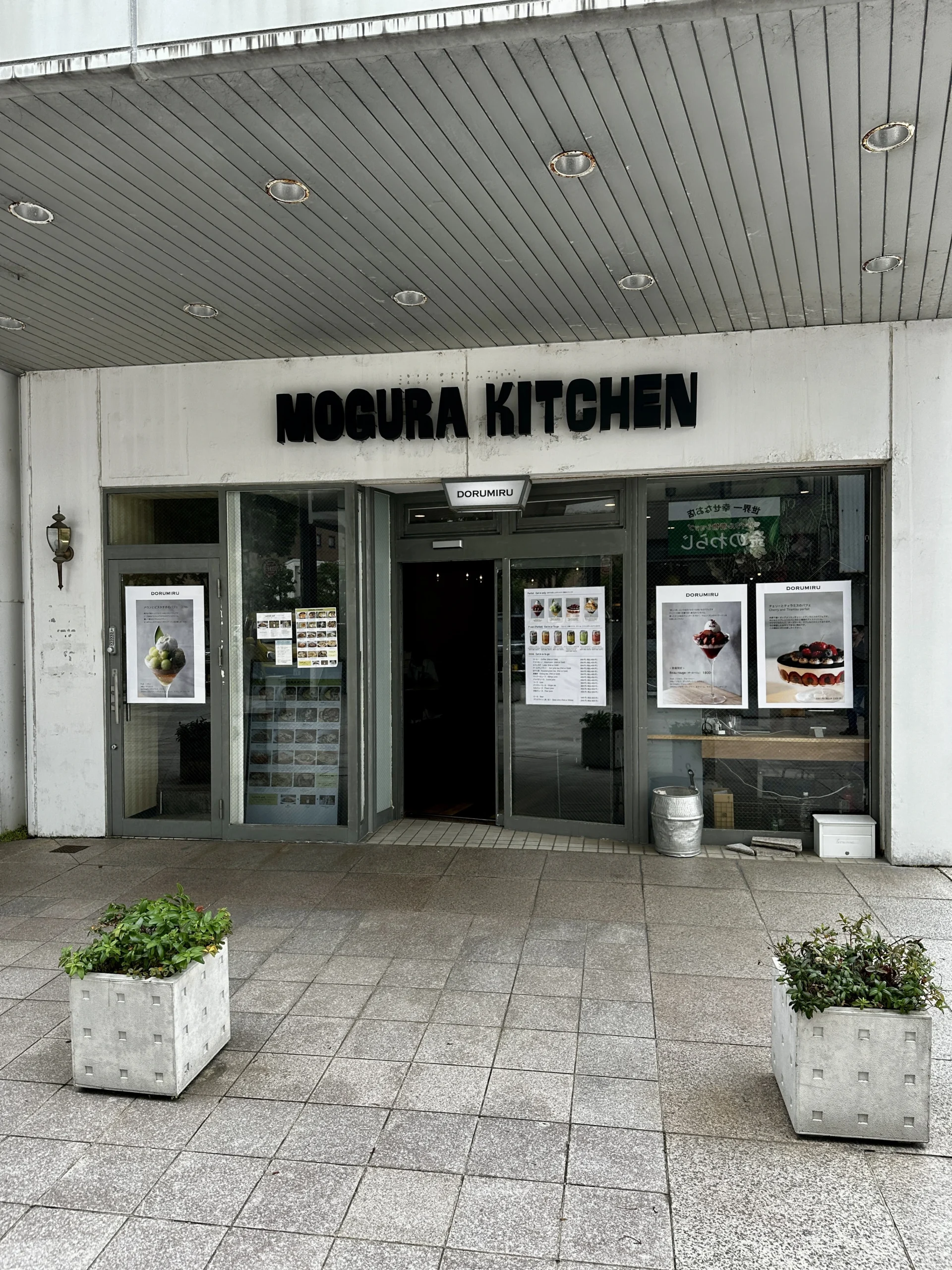 MOGURA KITCHEN竪町店の外観、白い壁と黒文字の看板
