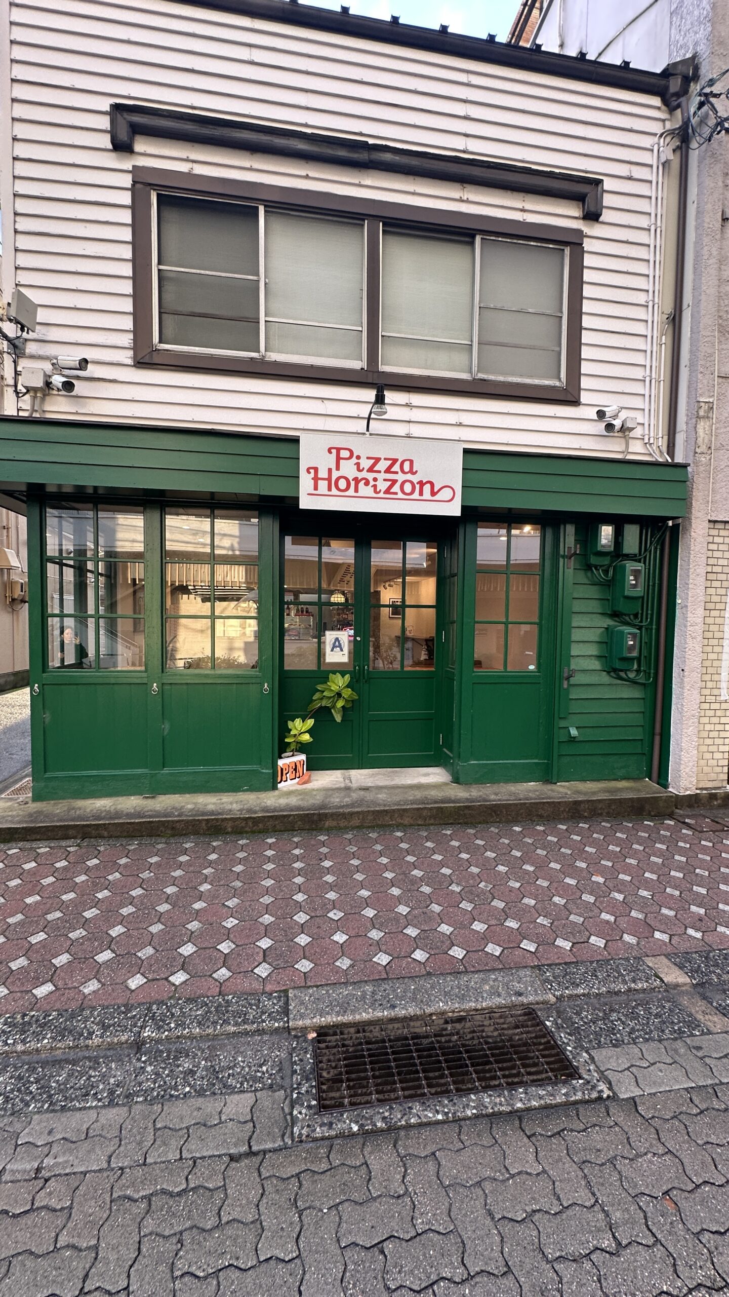 緑の外壁と白い看板の店舗外観