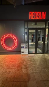 赤いネオンロゴが光るREDSUNの外観
