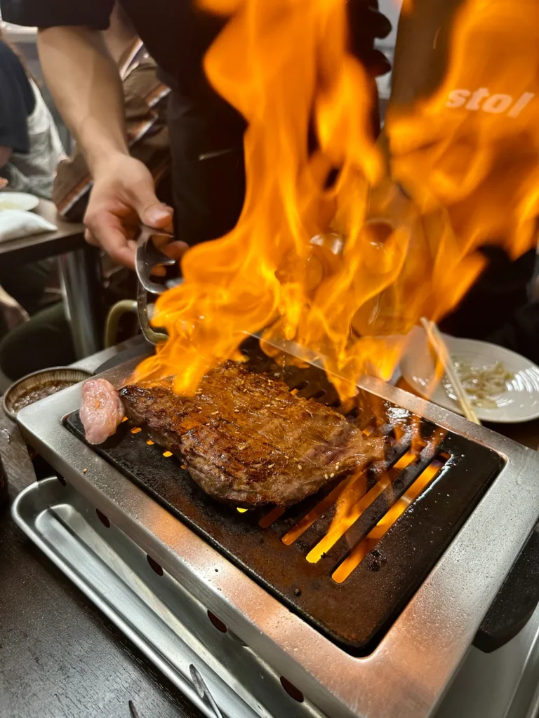 スタッフが炎を上げながら塊の和牛ハラミを焼く様子