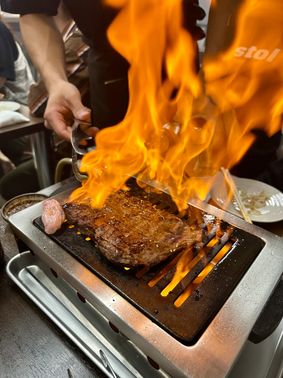 スタッフが炎を上げながら塊の和牛ハラミを焼く様子